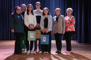  Grupa osób stoi na scenie, uśmiechają się do zdjęcia. Trzy młode osoby, trzymają papierowe torby z prezentami. Oprócz nich obecne są cztery kobiety, członkinie jury. Zdjęcie zostało wykonane po rozdaniu nagród, 