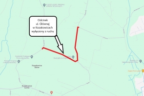 Grafika przedstawia mapę części miejscowości Kozakowice, na której zaznaczono zamknięcie odcinka ulicy Głównej. Zamknięty fragment drogi został wyróżniony czerwoną linią, a obok umieszczono tekst w dymku informujący: "Odcinek ul. Głównej w Kozakowicach wyłączony z ruchu". Zamknięcie dotyczy odcinka od skrzyżowania z ulicą Słoneczną do skrzyżowania z ulicą Stawową. Na mapie widoczne są także inne ulice oraz punkty orientacyjne, takie jak cmentarz ewangelicko-augsburski. Mapa służy do poinformowania o czasowych zmianach w organizacji ruchu w związku z prowadzonym remontem drogi.