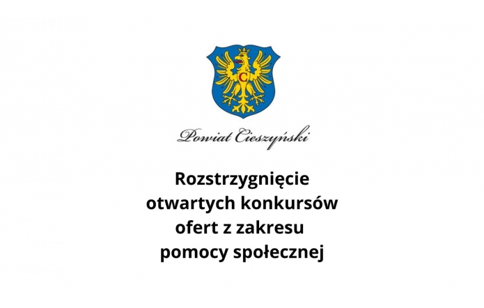 Na grafice widoczny jest herb Powiatu Cieszyńskiego, który przedstawia żółtego orła z koroną na niebieskim tle. Pod herbem znajduje się napis „Powiat Cieszyński”, a poniżej tekst informacyjny: „Rozstrzygnięcie otwartych konkursów ofert z zakresu pomocy społecznej”. Tło grafiki jest białe.