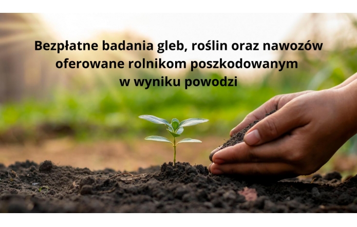 Na zdjęciu znajduje się młoda roślina wyrastająca z ziemi. Dłoń ludzka delikatnie trzyma ziemię wokół tej rośliny. W tle są rozmyte, naturalne kolory zieleni, co charakterystyczne dla gospodarstw rolnych lub wiejskich. Na grafice został umieszczony tekst – „Bezpłatne badania gleb, roślin oraz nawozów oferowane rolnikom poszkodowanym w wyniku powodzi”. 