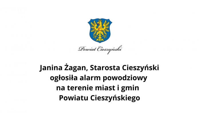 Grafika informacyjna z herbem Powiatu Cieszyńskiego i tekstem: "Janina Żagan, Starosta Cieszyński ogłosiła alarm powodziowy na terenie miast i gmin Powiatu Cieszyńskiego."