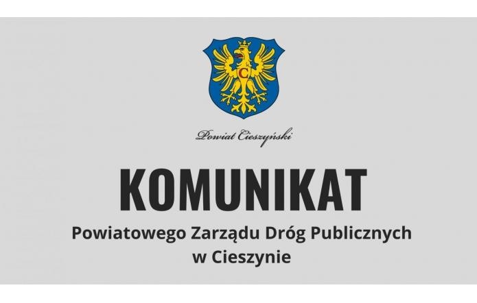 Grafika przedstawia prostokątny układ z tłem w odcieniach bieli. Na środku widnieje wyraźny napis „Powiat Cieszyński”. Poniże Powiatowego Zarządu Dróg Publicznych w Cieszynie. Litery są pogrubione, eleganckie i ciemne.