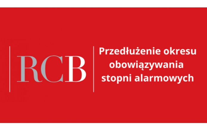 Grafika w czerwonym tle z dużym, szarym skrótem literowym "RCB" po lewej stronie. Po prawej stronie biały napis informacyjny w kilku liniach dotyczący przedłużenia okresu alarmowego.