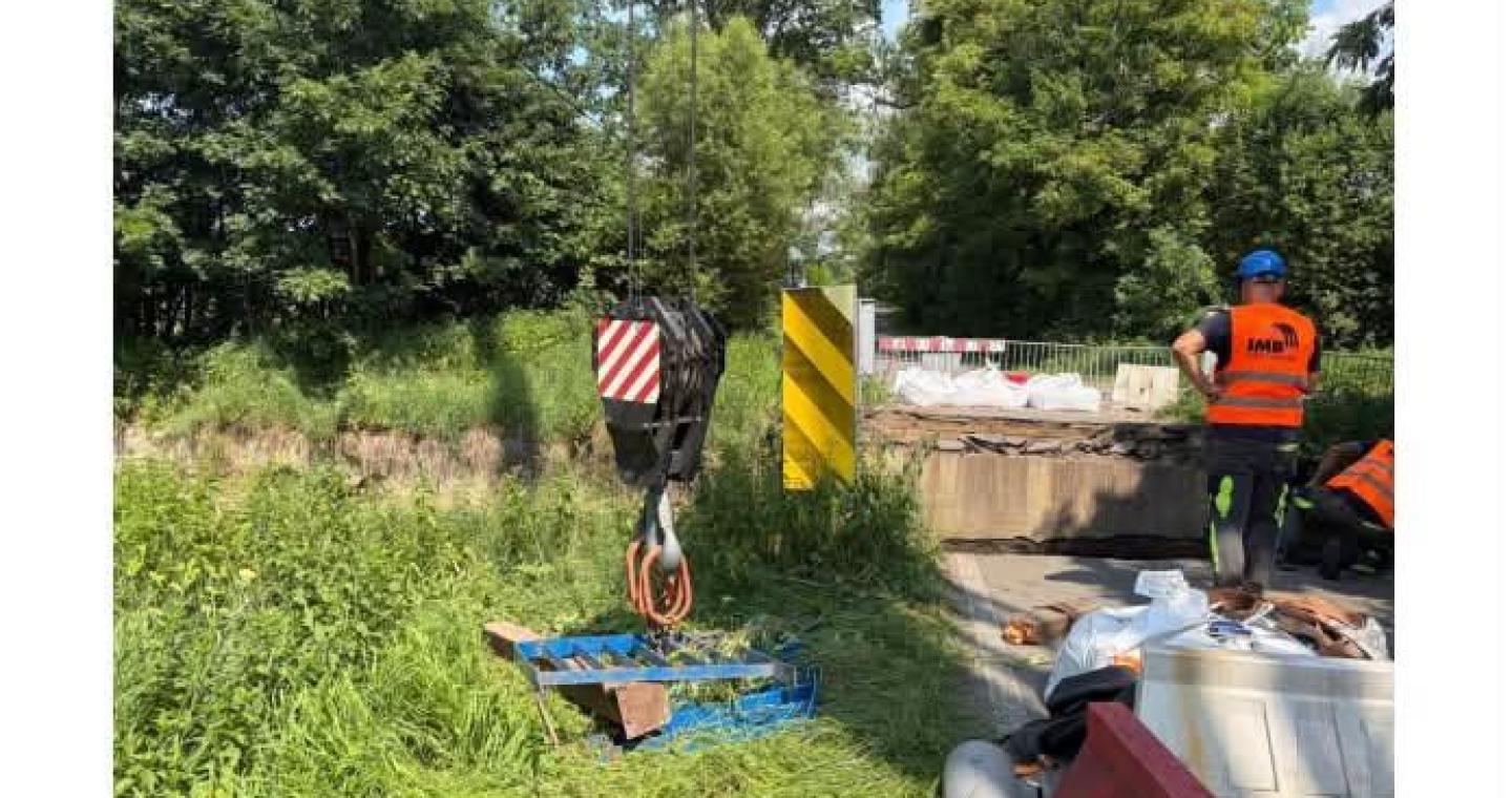 Robotnicy i sprzęt budowlany przy przeprawie podczas przygotowań do odbudowy mostu w Dębowcu.