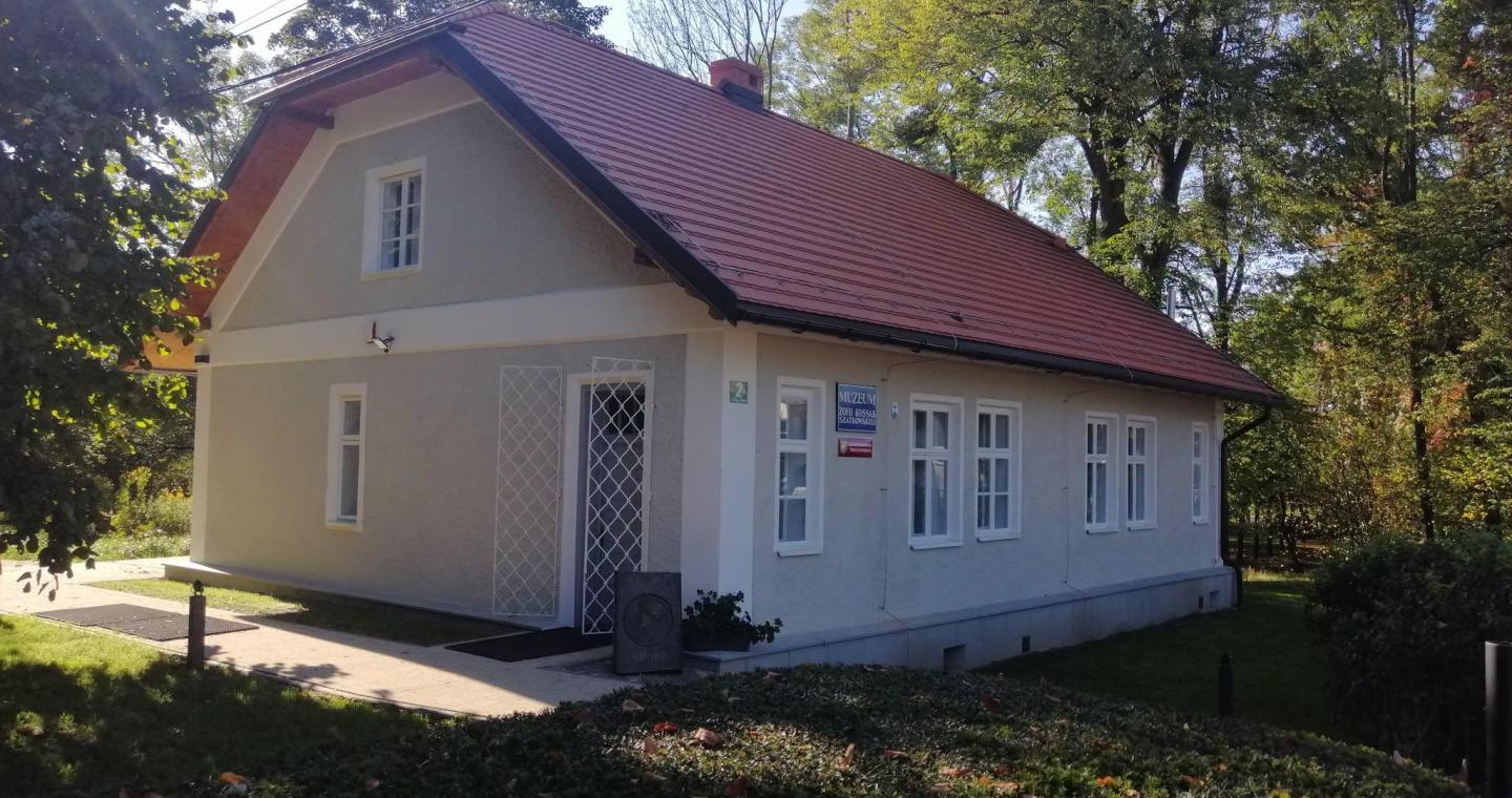 Odnowiony Domek Ogrodnika, siedziba Muzeum im. Zofii Kossak, wśród drzew.