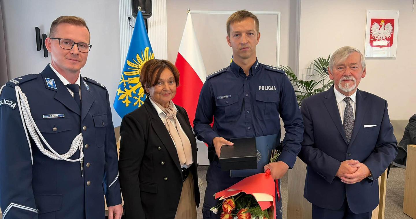 Aspirant Rafał Górczyński z wyróżnieniem i bukietem kwiatów w towarzystwie Janiny Żagan, Przemysława Żurata i Stanisława Kubiciusa.