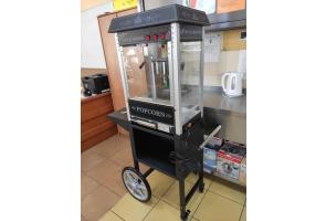 Maszyna do popcornu na metalowym wózku z kółkami, ustawiona przy kuchennym blacie. W tle czajnik elektryczny i szuflady w Zespole Placówek Szkolno-Wychowawczo-Rewalidacyjnych  w Cieszynie.