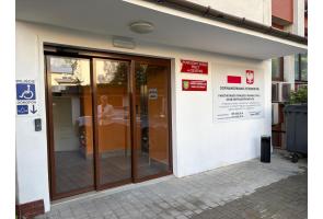 Wejście do Powiatowego Urzędu Pracy w Cieszynie, oznaczone jako dostępne dla osób na wózkach; obok tablica o dofinansowaniu przebudowy windy.