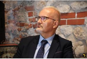 Mężczyzna w garniturze i okularach podczas obrad Konwentu Starostów Województwa Śląskiego.