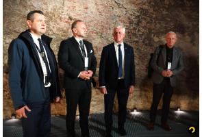 Czterech uczestników Konwentu Starostów Województwa Śląskiego stoi przed kamienną ścianą.