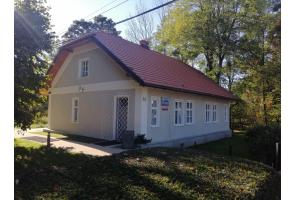 Odnowiony Domek Ogrodnika, siedziba Muzeum im. Zofii Kossak, otoczony drzewami.