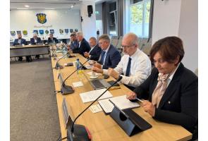 Zarząd powiatu podczas obrad Rady Powiatu Cieszyńskiego przy stole konferencyjnym.
