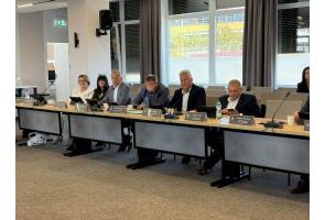 Radni podczas obrad sesji Rady Powiatu Cieszyńskiego siedzą przy stole konferencyjnym.