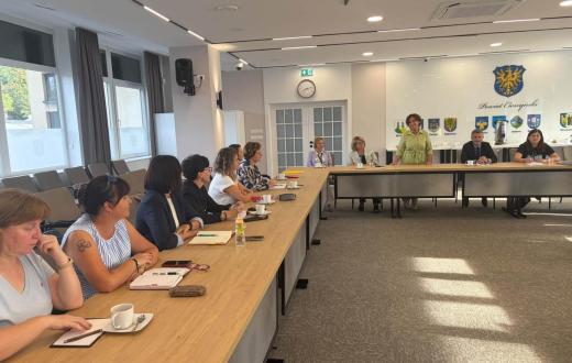 Uczestnicy spotkania dyrektorów szkół i placówek oświatowych prowadzonych przez Powiat Cieszyński siedzą przy stołach w sali konferencyjnej Starostwa Powiatowego w Cieszynie. Na stołach znajdują się dokumenty, notatniki i filiżanki.