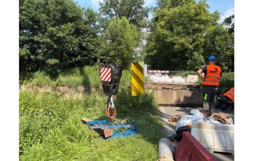 Robotnicy i sprzęt budowlany przy przeprawie podczas przygotowań do odbudowy mostu w Dębowcu.