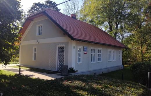 Odnowiony Domek Ogrodnika, siedziba Muzeum im. Zofii Kossak, wśród drzew.